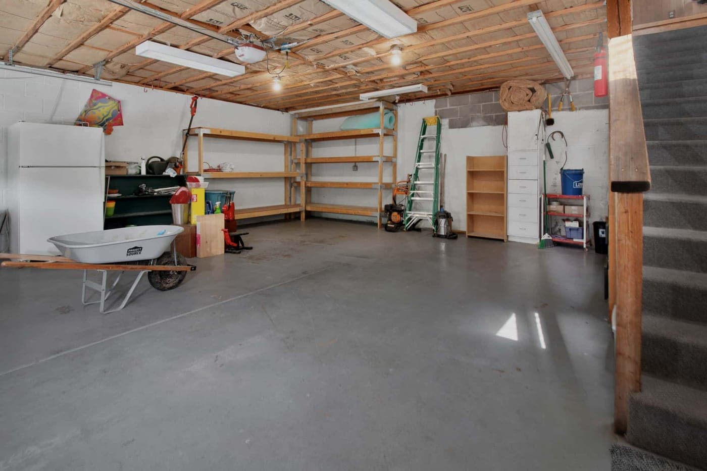 Storage boxes on an overhead rack near a garage ceiling
