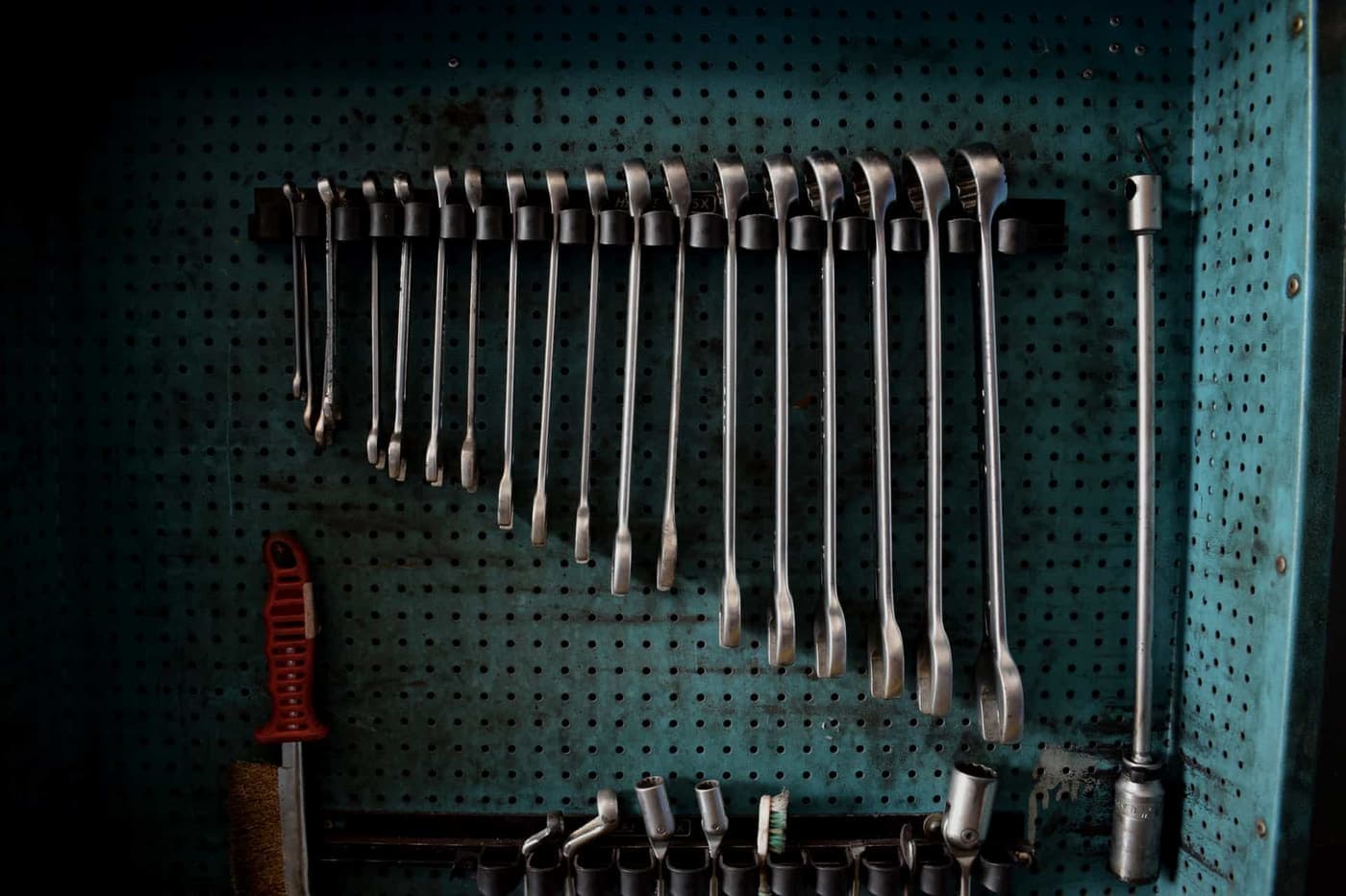 A garage wall with tools organized on hooks and panels