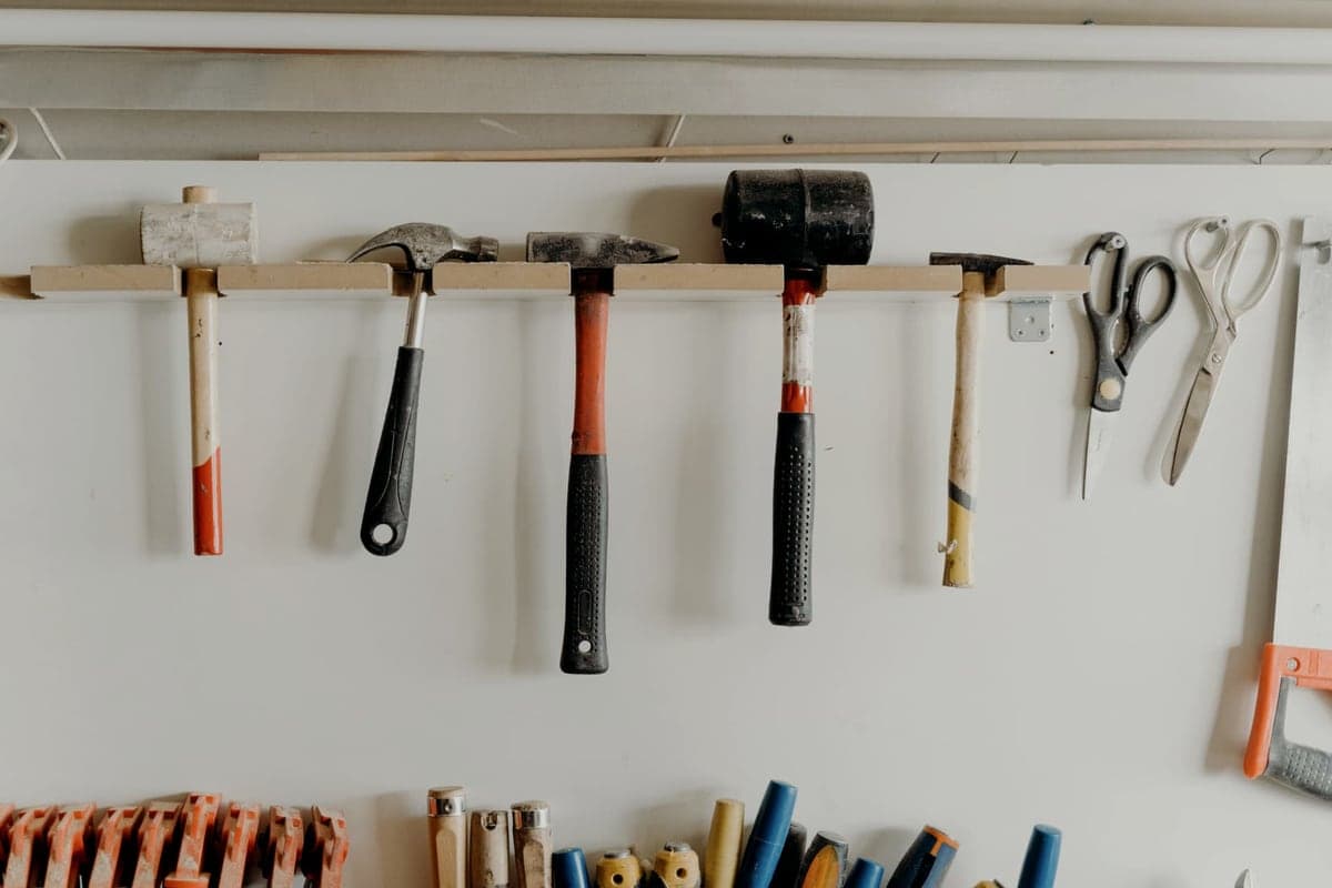 Hand tools hanging in an organized row on a workshop wall
