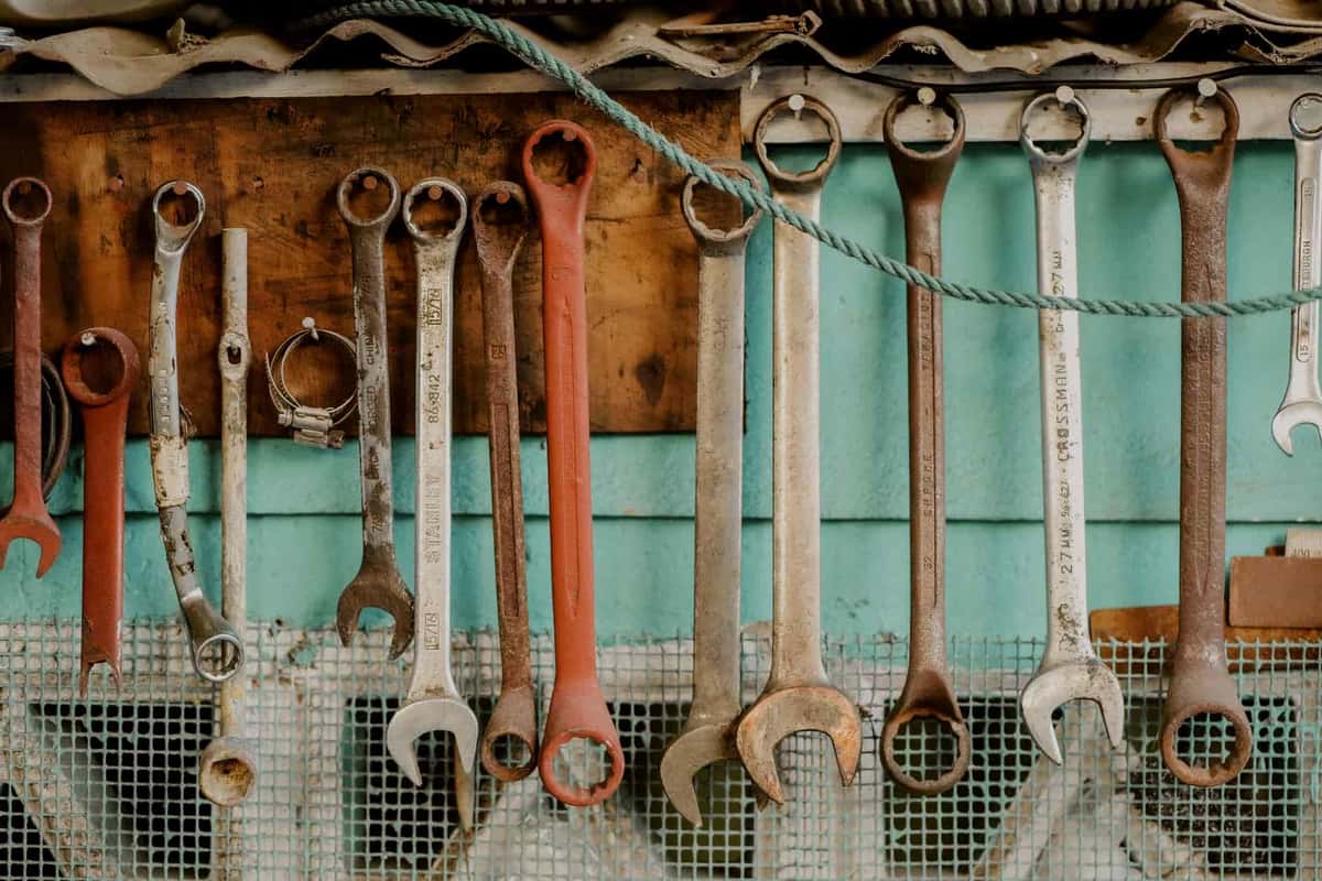A garage wall storage system with tools and equipment hanging on hooks